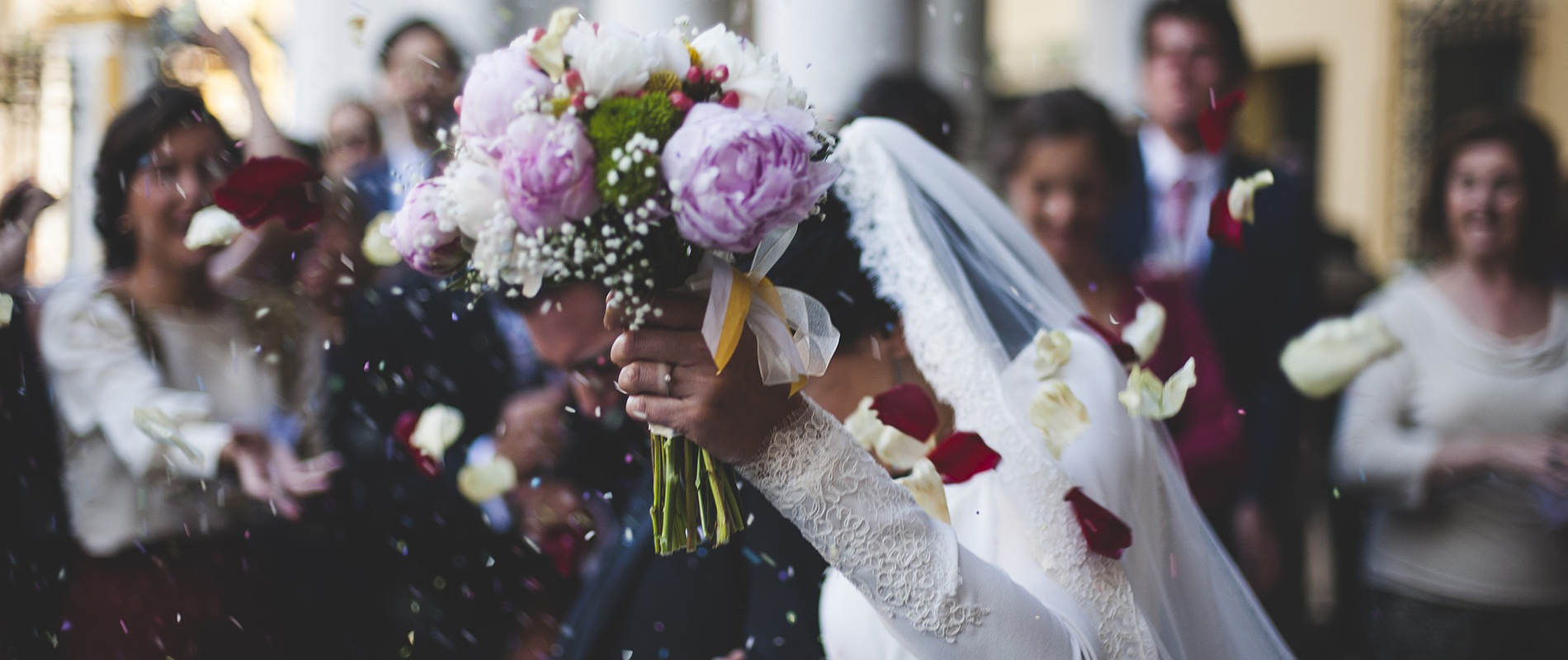 Eine Frau hält ihren Blumenstrauß an ihrer Hochzeit in die Höhe